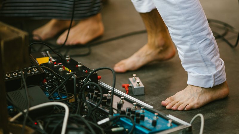 musician adjusting guitar pedals