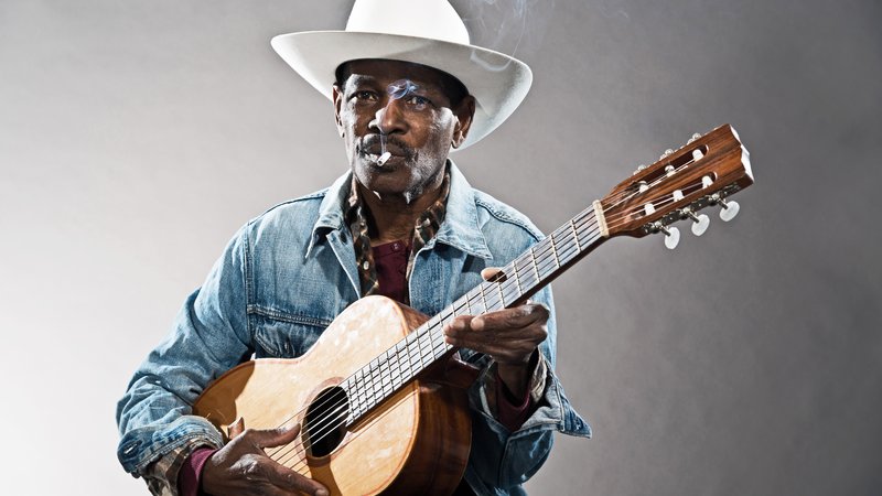delta blues musician playing acoustic guitar
